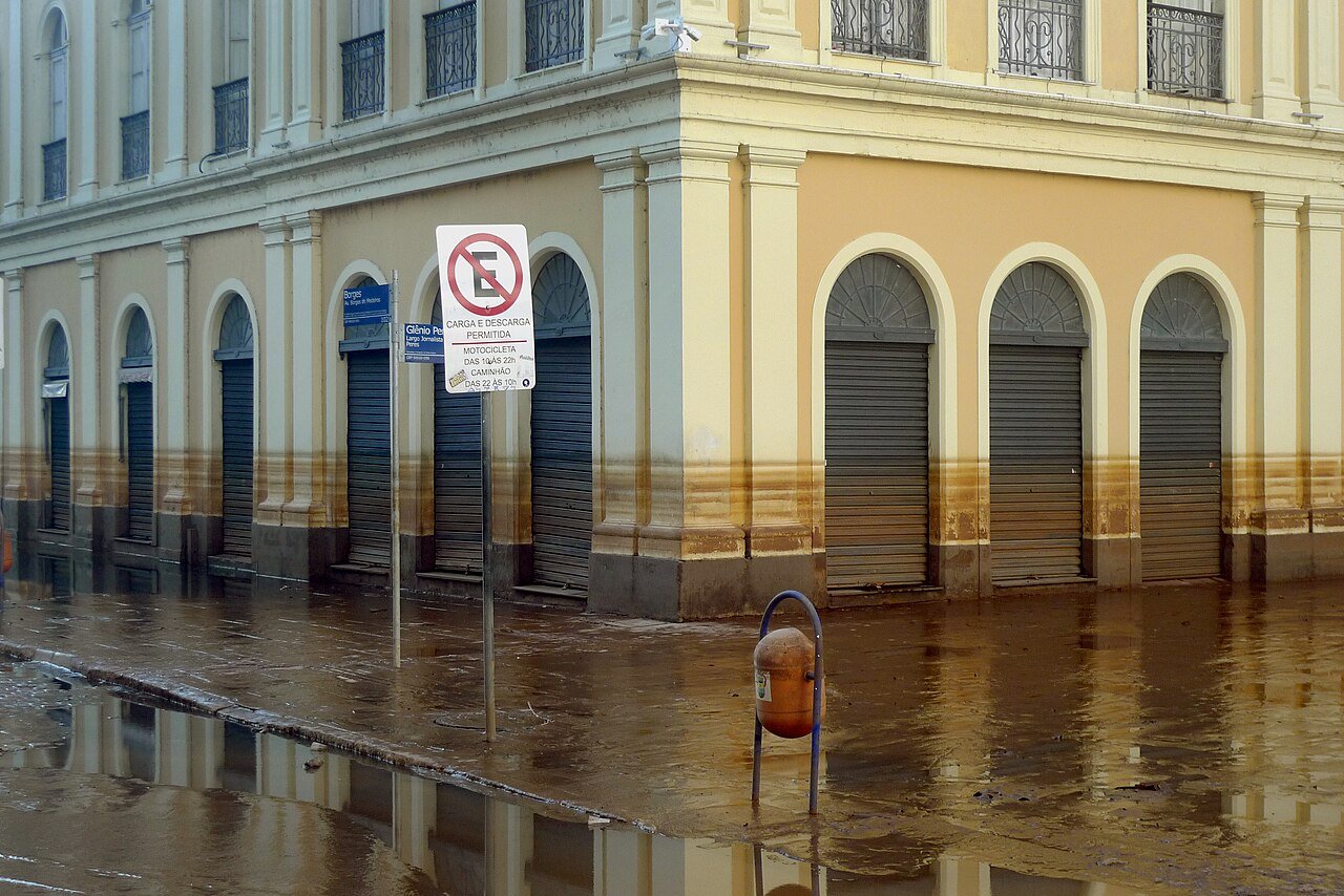 Rua alagada no centro de Porto Alegre com marcas de lama nas paredes dos prédios após a enchente de 2024